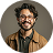 Cheerful curly haired man in tortoiseshell glasses