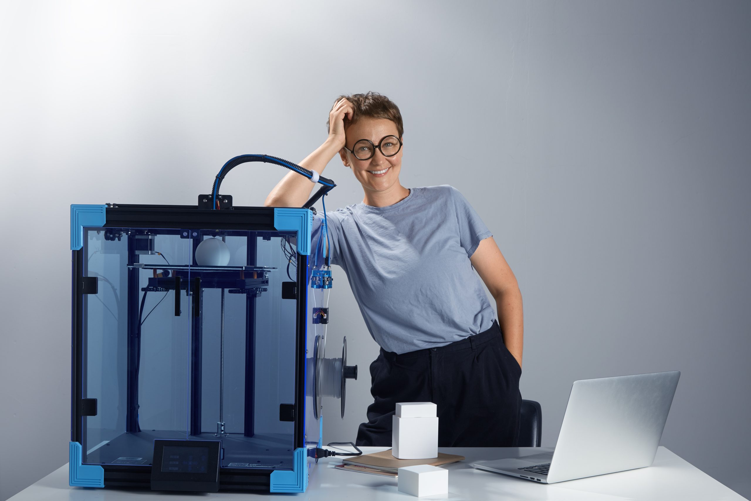 Young happy attractive woman entrepreneur with 3d printer making prototype production. process of 3d printing. horizontal high quality working environment photo image.